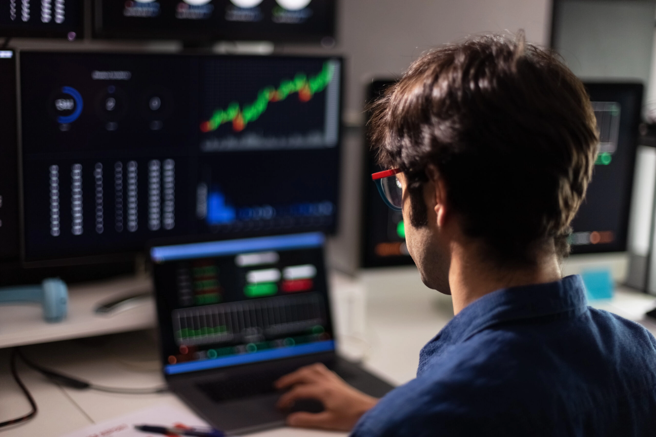 trader doing stock trading on multiple monitor screens